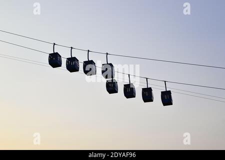 Ropeway cabins against clear sky. Rope way to the Savitri Mata Temple on the hill near Pushkar city. High contrast silhouette Stock Photo