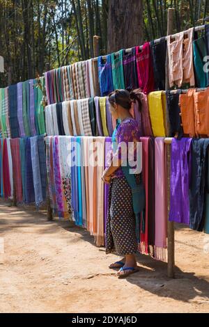 Burmese woman selling longis longyis at Shwe Indein Pagoda complex, Inle Lake, Shan State, Myanmar (Burma), Asia in February Stock Photo