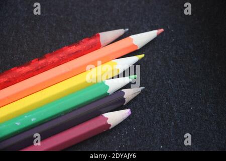 Colored pencils on dark grey background. Creativity concept. Equality and diversity concept. Stock Photo