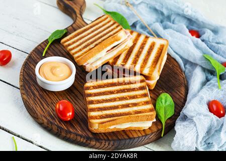 Club sandwich with ham, tomato, cheese and spinach. Grilled panini Stock Photo