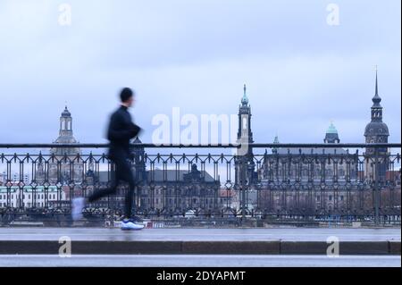 Dresden, Germany. 25th Dec, 2020. A man walks across the Marienbrücke against the backdrop of the old town. Credit: Sebastian Kahnert/dpa-Zentralbild/dpa/Alamy Live News Stock Photo
