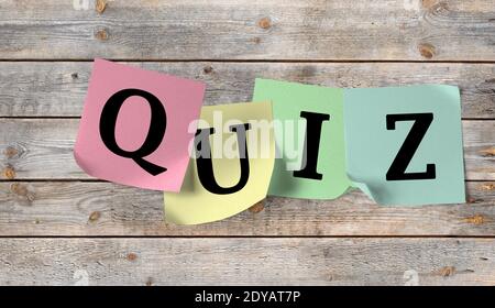 Sticky notes with the word Quiz on a wooden wall Stock Photo