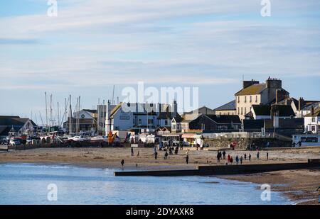 Lyme Regis, Dorset, UK. 25th Dec, 2020. UK Weather: Locals and families enjoy a morning walk along the beach on a bright, crisp and sunny Christmas day at Lyme Reegis. Credit: Celia McMahon/Alamy Live News Stock Photo