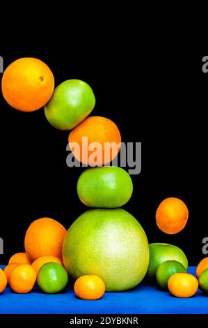Falling tower of citruses, oranges, pomelo, limes, tangerines and grapefruits isolated on black background Stock Photo