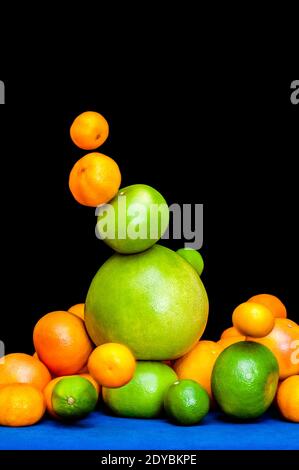 Falling tower of citruses, oranges, pomelo, limes, tangerines and grapefruits isolated on black background Stock Photo