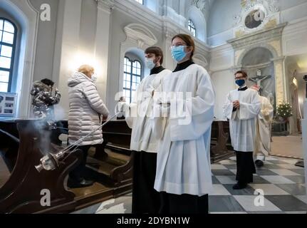 Dresden, Germany. 25th Dec, 2020. Altar servers celebrate the High Mass for Christmas in Dresden Cathedral on Christmas Day with a small number of faithful who had to register in advance for this service. Credit: Matthias Rietschel/dpa-Zentralbild/dpa/Alamy Live News Stock Photo