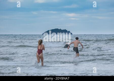 Polzeath, Cornwall, UK. 25th December 2020. UK Weather. Residents in Cornwall celebrated their last day in tier 1 with a swim in a chilly sea. Credit Simon Maycock / Alamy Live News. Stock Photo