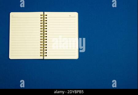 Notepad for notes on a simple blue background, flat design, top view, copy space, workplace photo Stock Photo