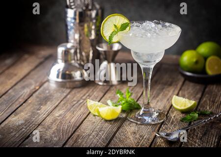 Cocktail margarita garnished with lime and mint on wooden background Stock Photo