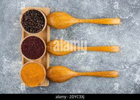 Different spices with wooden spoons on a gray background Stock Photo