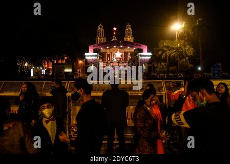 New Delhi, India. 25th Dec, 2020. People outside the barricade of Sacred Heart Cathedral on the occasion of Christmas celebrations, amidst the spread of the coronavirus disease (COVID-19), in New Delhi on December 25, 2020. Delhi's biggest church, the Sacred Heart Cathedral, reemained shut on Christmas for the very first time ever in wake of the coronavirus. Credit: David Talukdar/ZUMA Wire/Alamy Live News Stock Photo