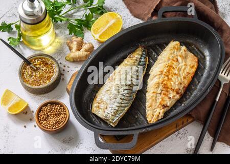 Grilled baked mackerel with ginger mustard honey sauce on a marble table top. Stock Photo