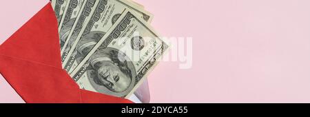 Banknotes of 100 dollars in a red envelope on a light background Stock Photo
