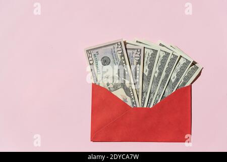 Banknotes of 100 dollars in a red envelope on a light background Stock Photo