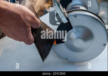 Sharpening knife on old grindstone wheel Stock Photo - Alamy