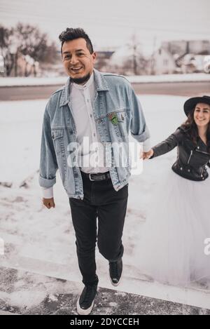 Hispanic man in oversized denim jacket and woman in hat leather biker jacket Stock Photo