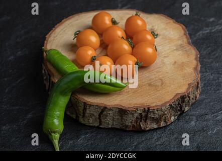 Close up photo Green hot pepper and cherry tomatoes on the wood piece Stock Photo