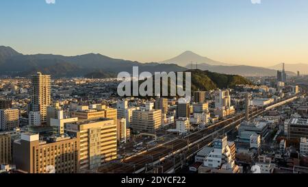 Cityscape at sunrise with Mt Fuji and railway lines with shinkansen, Shizuoka, Japan Stock Photo