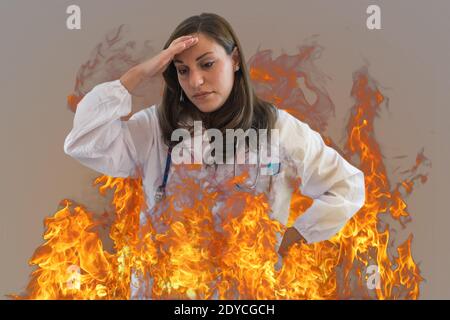 Burning female doctor explains the concept of burn out syndrome in healthcare professions. Stock Photo