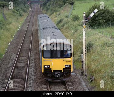 Edale, Hope Valley, UK - 18 July 2020: A passenger train (Class 150) operated by Northern passing a semaphore signal near Edale station. Stock Photo