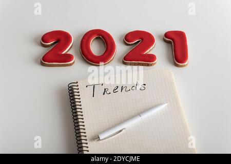 set of numbers 2021 and notebook with inscription TRENDS on white background. Fashion trends in the new year. Stock Photo
