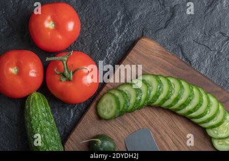 Fresh vegetables sliced on a wet black table. Tomato and cucumber slices Stock Photo