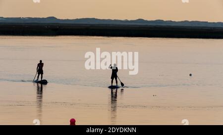 pair of stand up paddlers in the dawn Stock Photo