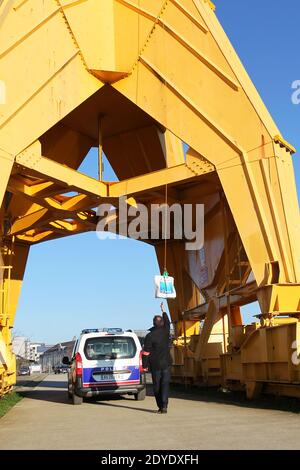 Two french police members attach a water bottle bag destined to Serge Charnay, who stands on a giant crane disused on February 17, 2013 in Nantes. Serge Charnay is on his third day of a protest for his rights as a father. Photo by Laetitia Notarianni/ABACAPRESS.COM Stock Photo