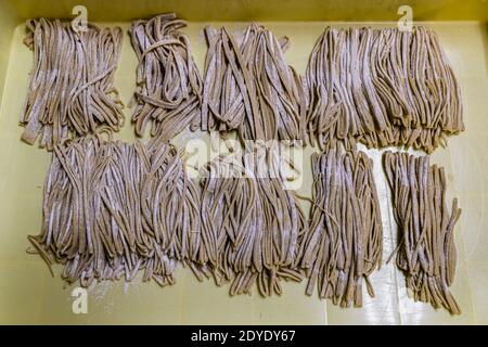 Soba Noodle Preparation in Fujinomiya, Japan. Soba noodles ready for the cooking pot. That an unskilled worker was also at work here can be seen from the strips, some of which are much too thick