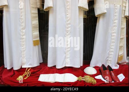 The tiny, old-fashioned shop 'Gammarelli' in downtown Rome, Italy displayed on March 4, 2013 the three sets of white vestments to be shipped to the Vatican for the new pope. Here have been made three versions, small, medium and large of the white vestments the new pope will wear when he first appears to the world. 'Gammarelli', as the ecclesiastical fashion house is known, has dressed the spiritual leaders of the Roman Catholic Church since 1798. 'We have prepared three vestments in white wool, a stole, red loafers, a skullcap, as well as a red velvet cape with a white fur border since it's wi Stock Photo