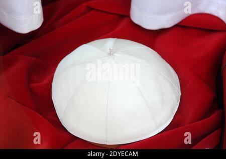 The tiny, old-fashioned shop 'Gammarelli' in downtown Rome, Italy displayed on March 4, 2013 the three sets of white vestments to be shipped to the Vatican for the new pope. Here have been made three versions, small, medium and large of the white vestments the new pope will wear when he first appears to the world. 'Gammarelli', as the ecclesiastical fashion house is known, has dressed the spiritual leaders of the Roman Catholic Church since 1798. 'We have prepared three vestments in white wool, a stole, red loafers, a skullcap, as well as a red velvet cape with a white fur border since it's wi Stock Photo