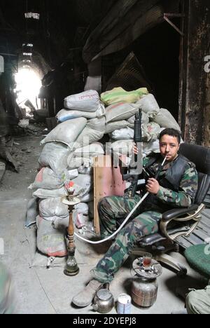 Free Syrian Army 'Al Tawhid' brigade member seen with a waterpipe or narguileh in the old market (souk) next to the Great Mosque or the Umayyad Mosque, in the center of Aleppo, Syria, on March 16, 2013. The mosque was built in the beginning of the 8th century. And its most 'recent' part was achieved in 1090. The prophet Zacharie's shrine is located inside. The mosque has been partly burned and destroyed during the fights. Photo by Ammar Abd Rabbo/ABACAPRESS.COM Stock Photo