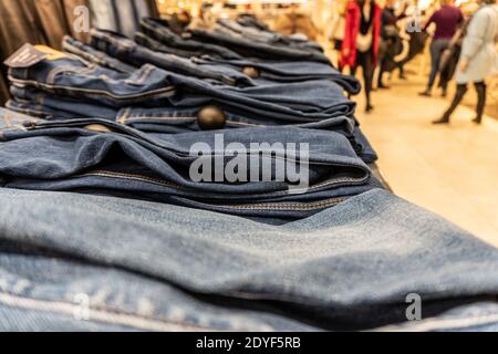 A stack of denim pants in a mall lies in rows Stock Photo