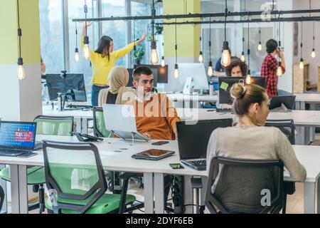 Successful team. Group of young business people working and communicating together in creative office Stock Photo