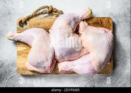 Raw chicken thighs on a chopping Board. Gray background. Top view Stock Photo