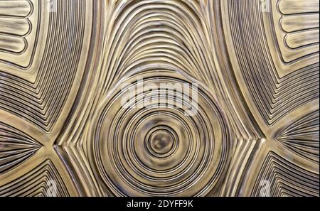 Golden with patina plastic 3D panel with wavy texture. Decorative panel with a volumetric pattern. Stock Photo