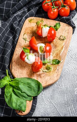 Mozzarella Cheese canape sandwiches on skewers, Caprese salad. gray background. top view Stock Photo