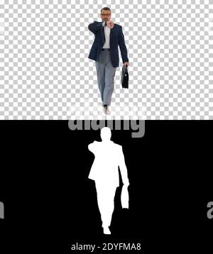 Mature businessman walking in a hurry and looking at watch, Alph Stock Photo