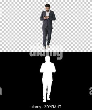 Businessman walking and using the phone, Alpha Channel with Silh Stock Photo