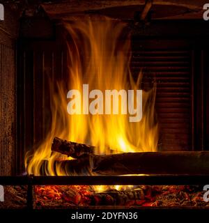 A fire lit inside a forced air fireplace Stock Photo