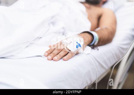 Patient lying in hospital bed after surgery. Hospitalization and medical care concept. Stock Photo