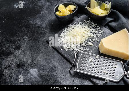 Pieces of parmigiano reggiano hard cheese. Slice, cut, grated. Black background. Top view. Copy space Stock Photo