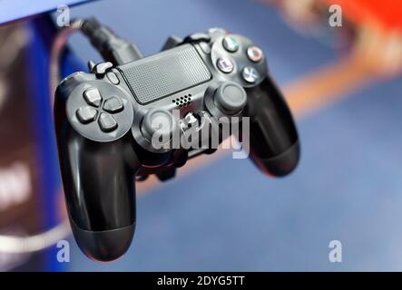PS4 controller closeup, shallow depth of field. PlayStation 4 pad plugged in up close. Console gamepad, input devices concept, technology, nobody Stock Photo