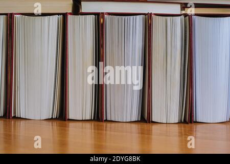A row of half-open books lying on the desk Stock Photo