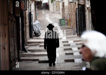Orthodox Jews walk along Ancient Alley in Jewish Quarter of Jerusalem city, Israel Stock Photo