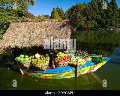 boat loaded with vegetables and fruits. transportation of goods by river in southeast asia. Stock Photo