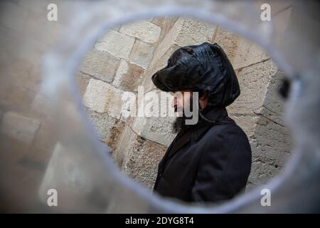 Orthodox Jews walk along a street in the oldtown of Jerusalem city during a rain, Israel Stock Photo