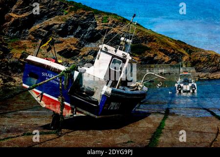 A fishing boat anchored in Port Isaac bay when the tide is  out. The village where Doc Martin was filmed. Stock Photo
