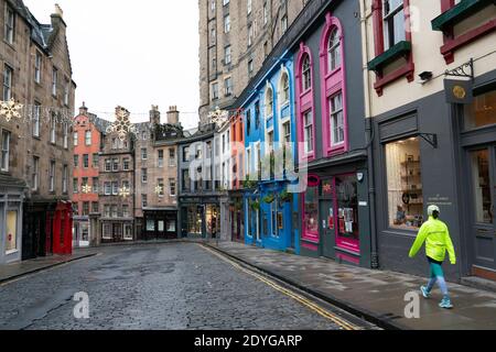 Edinburgh, Scotland, UK. 26 December 2020. Scenes from Edinburgh City Centre on a wet and windy Boxing Day during storm Bella. Today is first day that Scotland is under level 4 lockdown and all non essential shops and businesses are closed. As a result the streets are almost deserted with very few people venturing outside. Pic; Shops on historic Victoria Street is closed and virtually deserted.  Iain Masterton/Alamy Live News Stock Photo