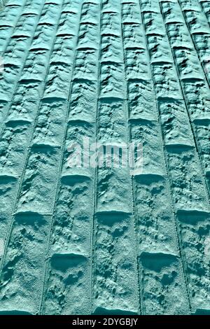 Textured turquoise stone wall forms geometric abstract background pattern Stock Photo
